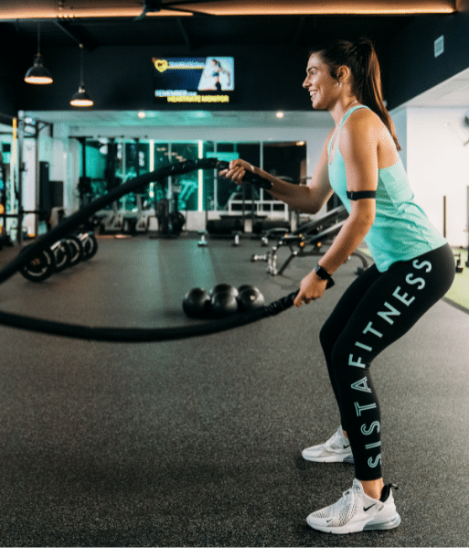 Woman training with battle ropes at the gym