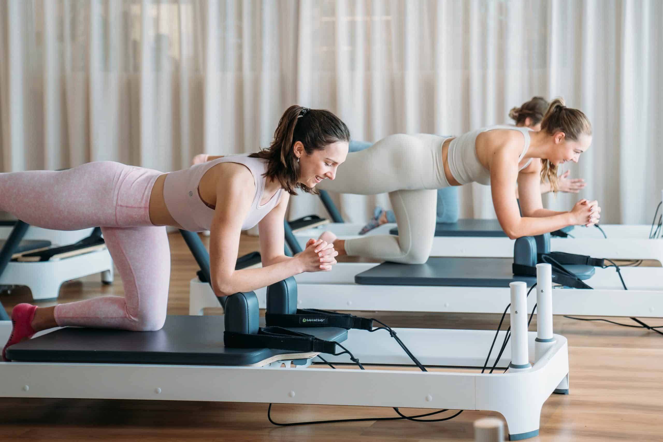 Women training on pilates machines