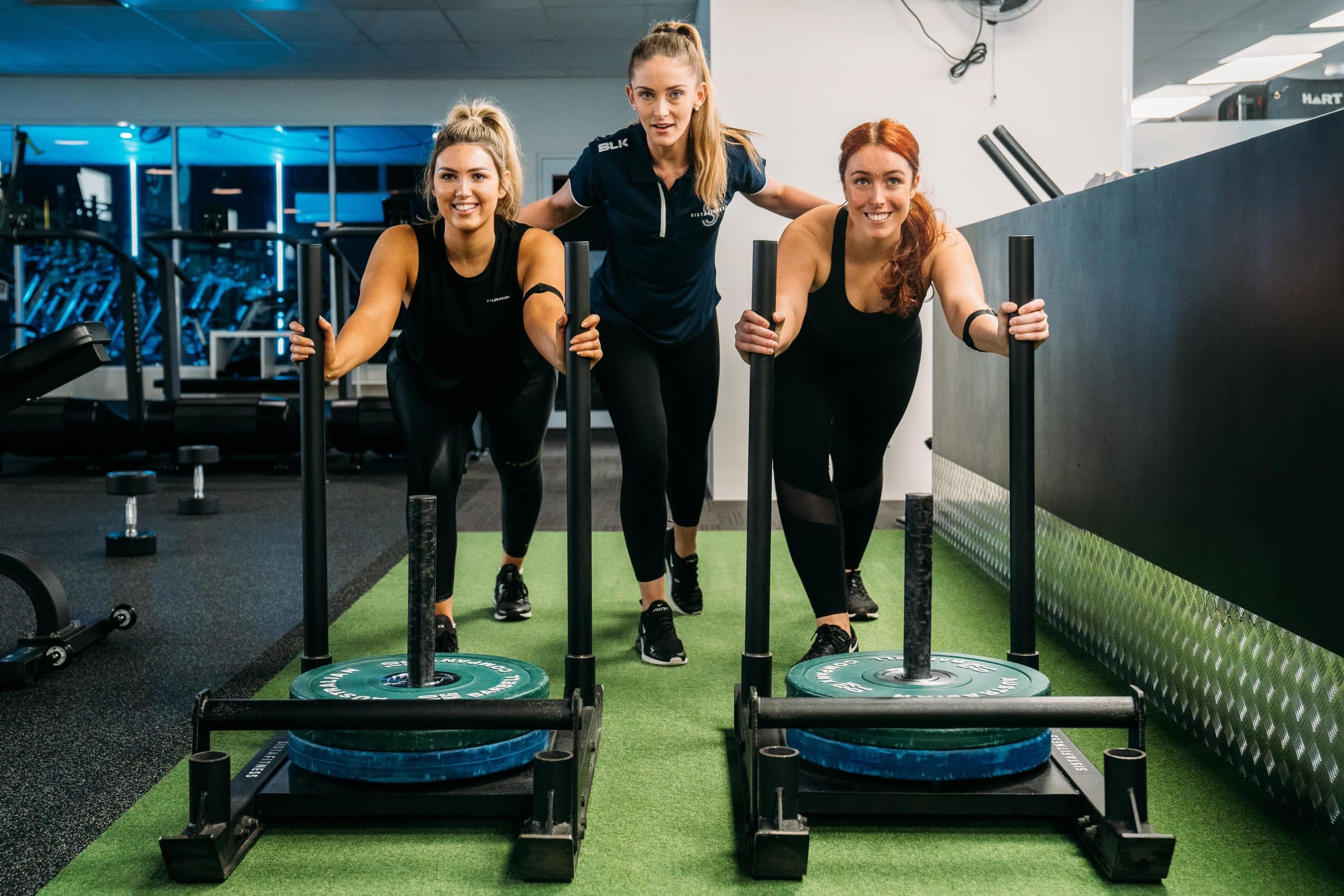 Two women pushing heavy weights, functional training