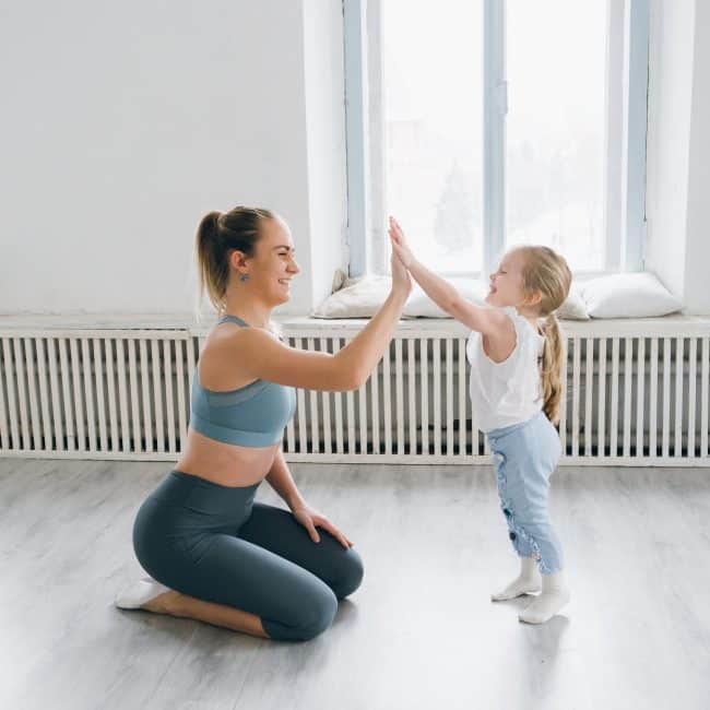 Gym mum high fiving a young girl