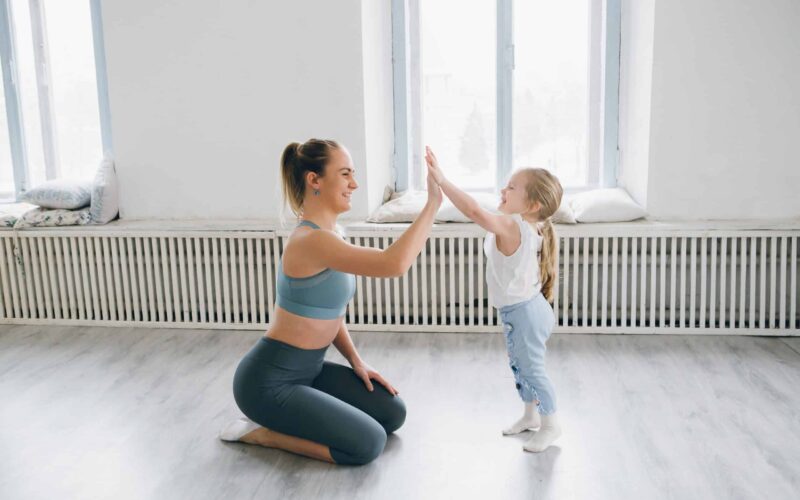 Gym mum high fiving a young girl